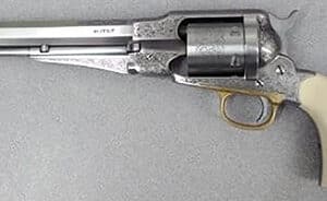 Engraved silver revolver with ivory grip on display.