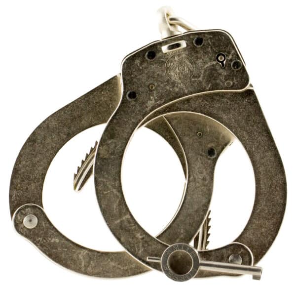 Close-up of vintage Smith & Wesson handcuffs with key.