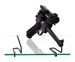 Black handgun on display stand, isolated background.