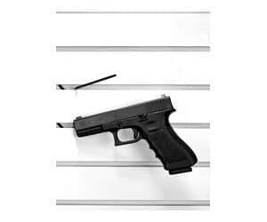 Black handgun displayed on white shelf
