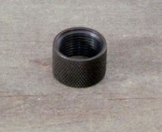 Black threaded cap on wooden surface.