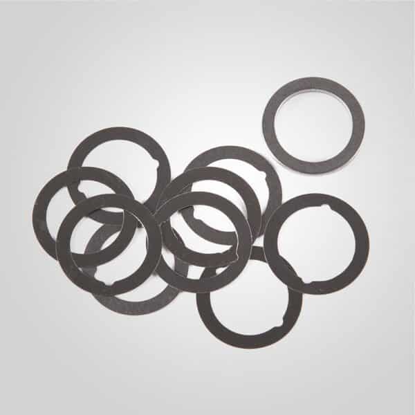 Pile of black metal washers on gray background.
