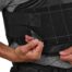 Person adjusting black back brace strap